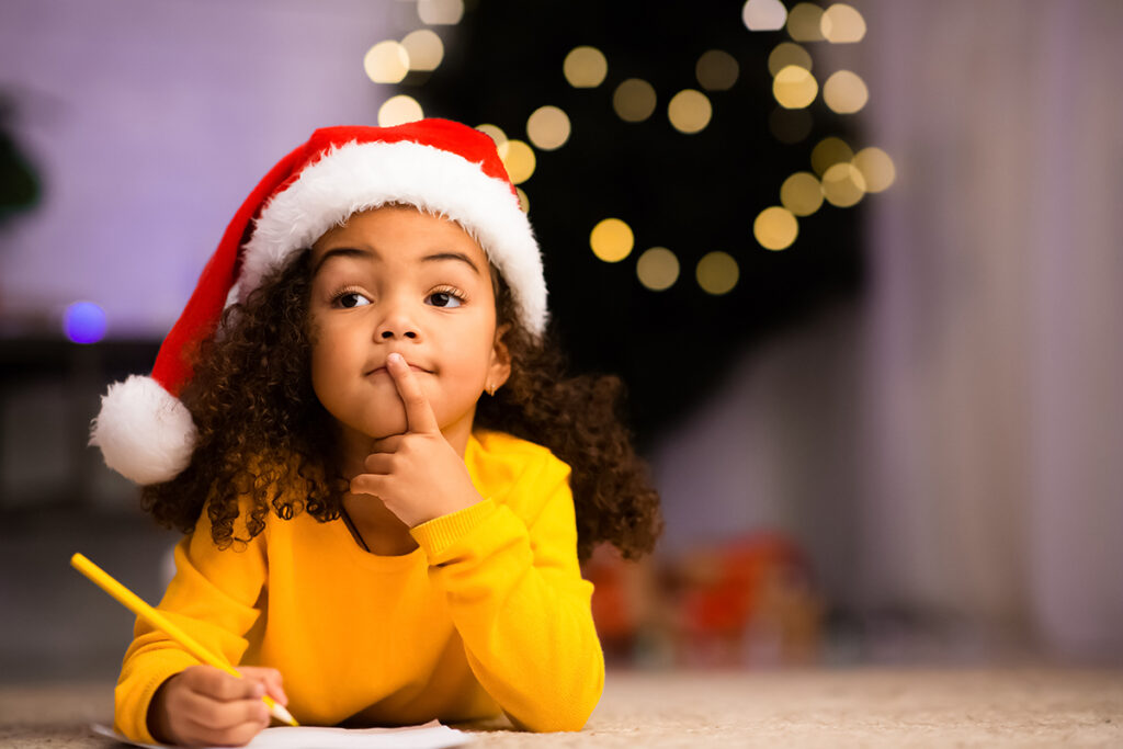 Holiday Prep Guide: How to Prepare for Your Chat with Santa 42 A little girl writes a Wish List before her video call with Santa
